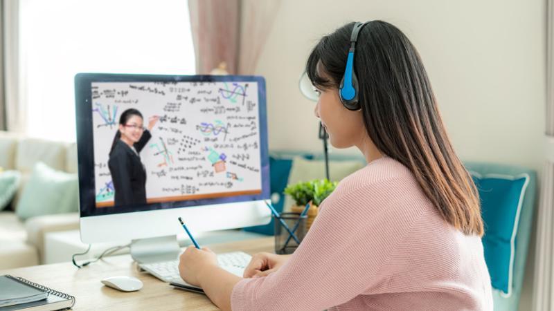 女学生在家办公，老师在电脑屏幕前讲课